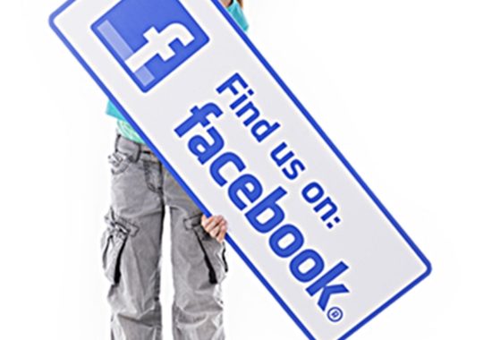 girl holding sign that reads "find us on facebook"