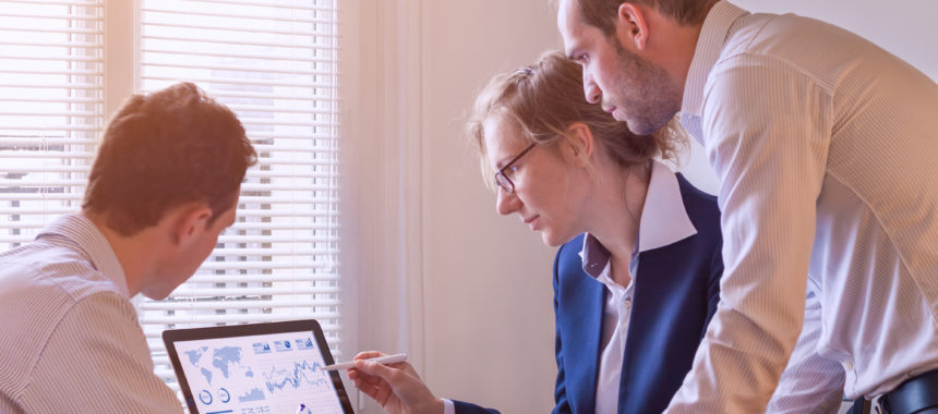 Team of people investigating marketing measurement on computer